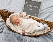 Neugeborenes Baby in einem Korb, trägt ein helles Outfit. Neben dem Baby steht ein Schild mit der Aufschrift "Willkommen Ida".